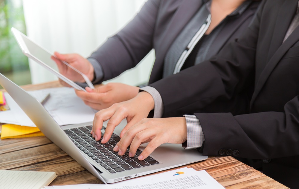 Business users accessing and managing documents electronically on a laptop and tablet