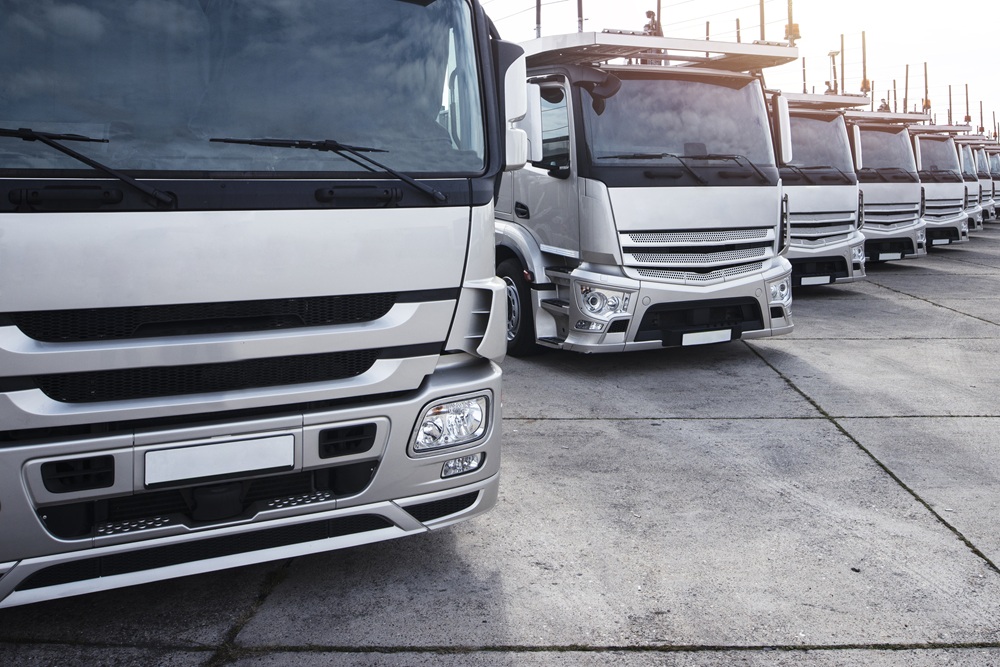Row of commercial trucks parked in a fleet yard ready for daily operations
