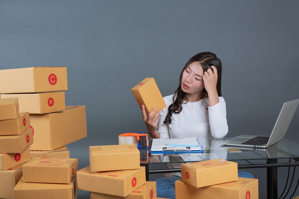 Overwhelmed logistics worker surrounded by packages